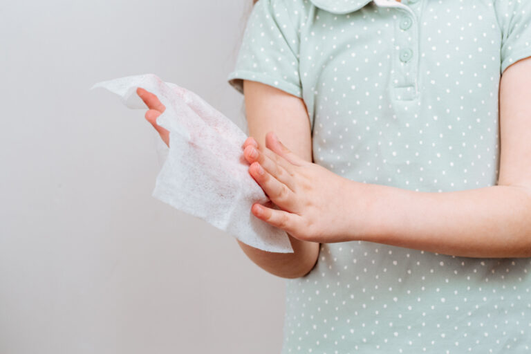 child wipes her hands wet antibacterial wipe